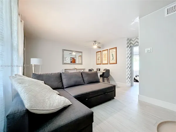 a living room with couches and a potted plant on table