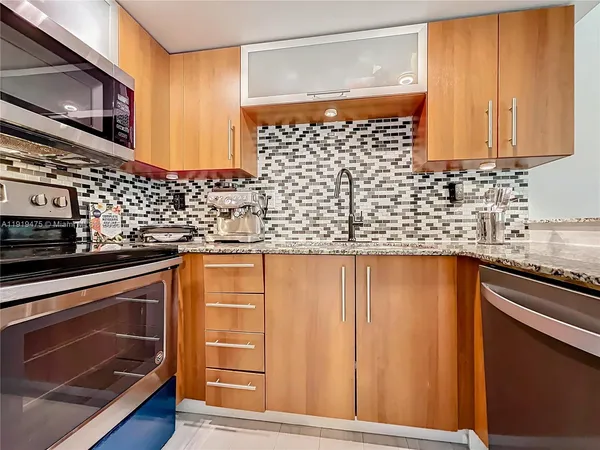 a kitchen with stainless steel appliances wooden cabinets and a stove top oven