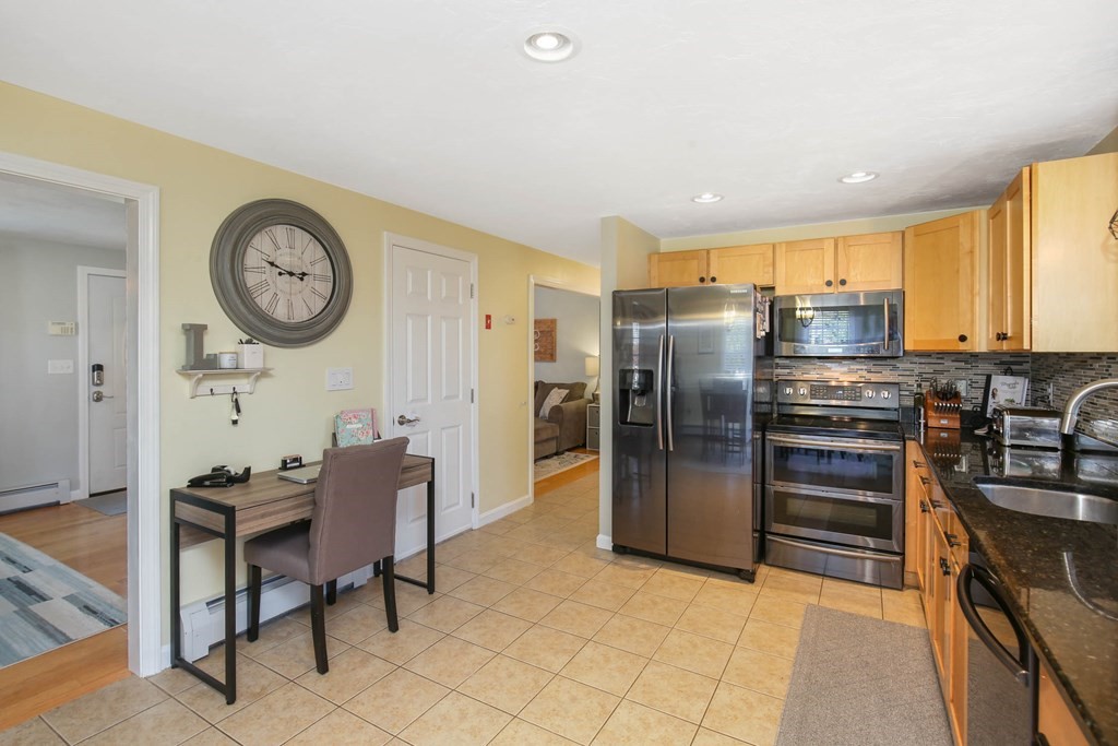 20 El Caney Road Worcester, MA 01603 - Photo 14 of 37 a kitchen with stainless steel appliances granite countertop a refrigerator and a stove top oven