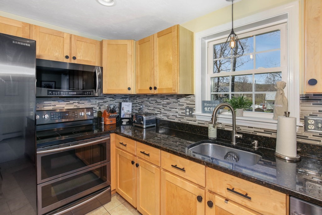 20 El Caney Road Worcester, MA 01603 - Photo 16 of 37 a kitchen with granite countertop cabinets stainless steel appliances and a sink