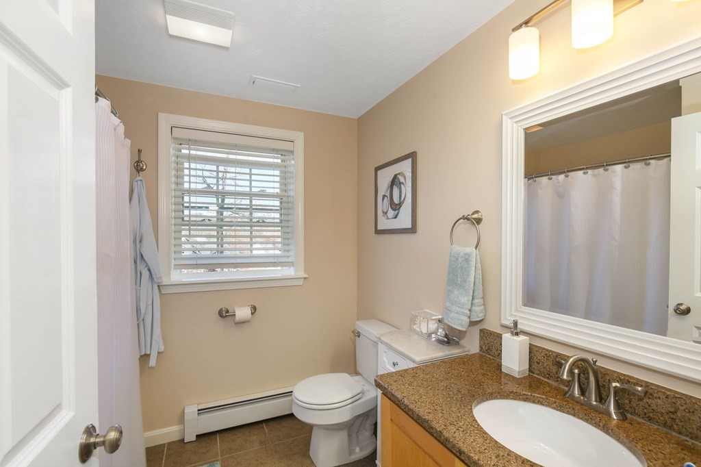 20 El Caney Road Worcester, MA 01603 - Photo 26 of 37 a bathroom with a granite countertop toilet a sink and a mirror