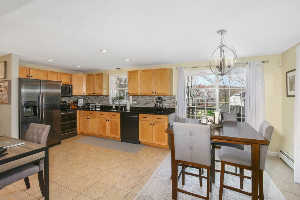 20 El Caney Road Worcester, MA 01603 - Photo 8 of 37 a kitchen with refrigerator cabinets dining table and chairs