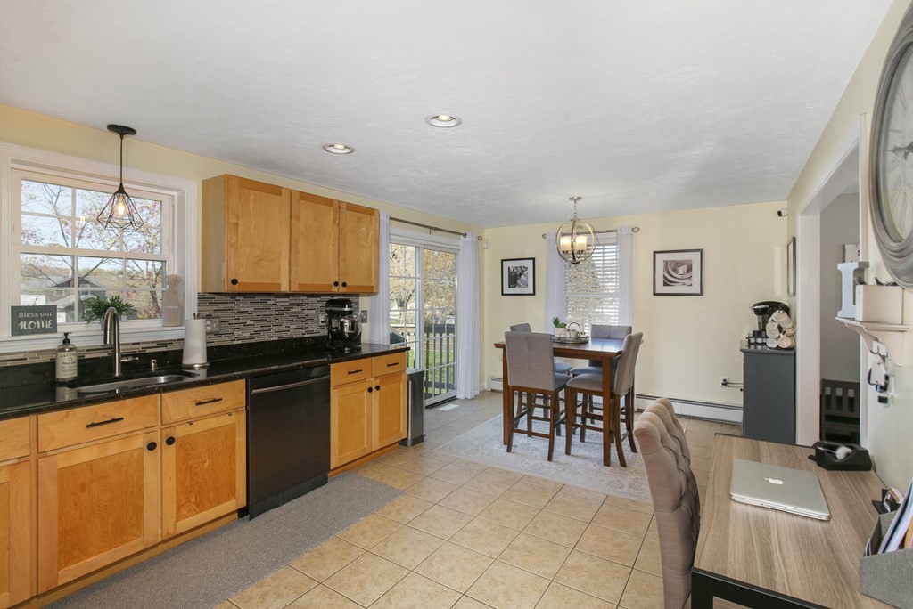 20 El Caney Road Worcester, MA 01603 - Photo 10 of 37 a large kitchen with kitchen island granite countertop a sink a stove a dining table and chairs