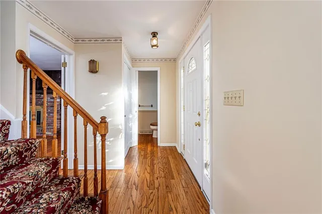a view of a hallway with wooden floor and staircase