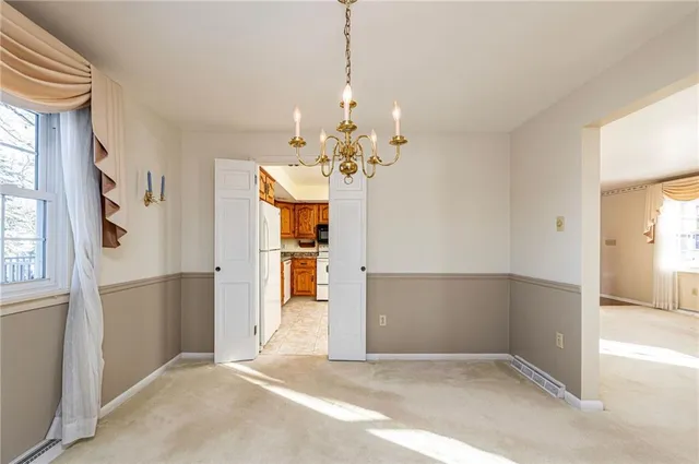 a view of a livingroom with a chandelier fan and windows