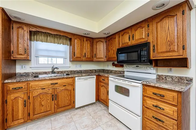 a kitchen with stainless steel appliances granite countertop a stove microwave and sink