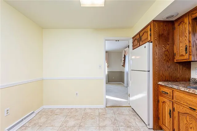 a view of a refrigerator in kitchen and a window