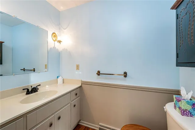 a bathroom with a sink mirror vanity and toilet