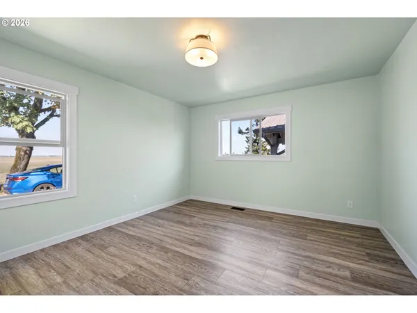 an empty room with wooden floor and painting on the wall