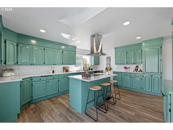 a kitchen with kitchen island granite countertop a sink a counter space appliances and cabinets