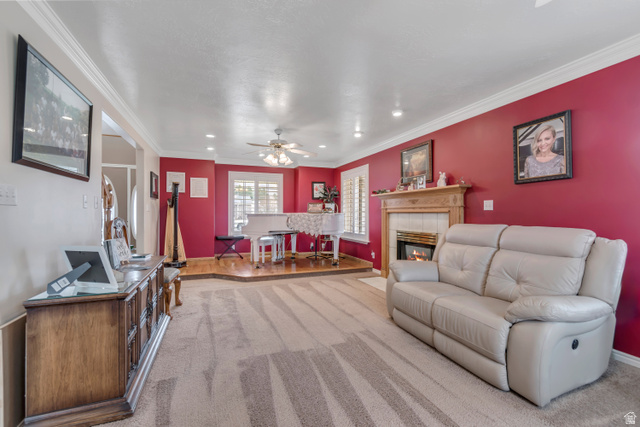 1697 North 500 West Mapleton, UT 84664 - Photo 5 of 50 Living room with carpet floors, a tiled fireplace, ornamental molding, a ceiling fan, and recessed lighting