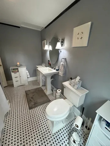 a bathroom with a toilet a sink and a mirror