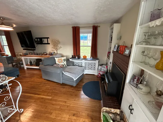 a living room with furniture a flat screen tv and a fireplace