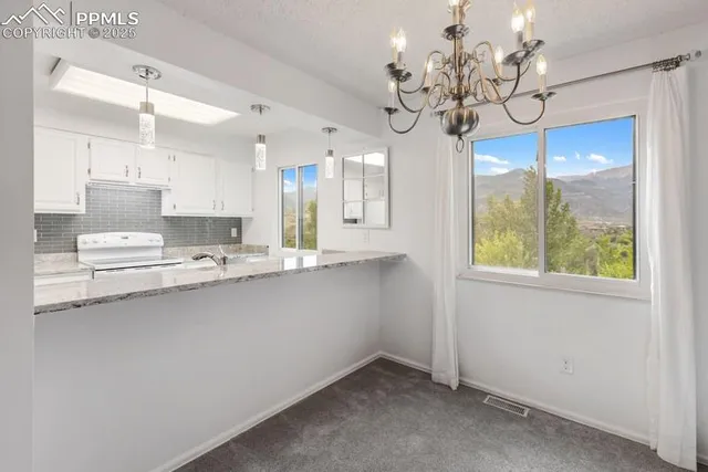 a kitchen with stainless steel appliances a chandelier and cabinets