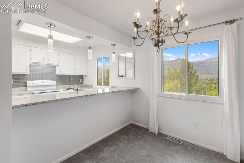 938 Fontmore Road, Unit B Colorado Springs, CO 80904 - Photo 14 of 30 a kitchen with stainless steel appliances a chandelier and cabinets