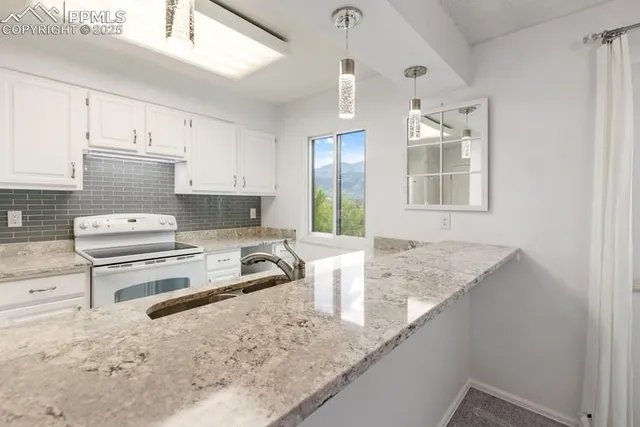 a kitchen with stainless steel appliances granite countertop a sink stove and cabinets