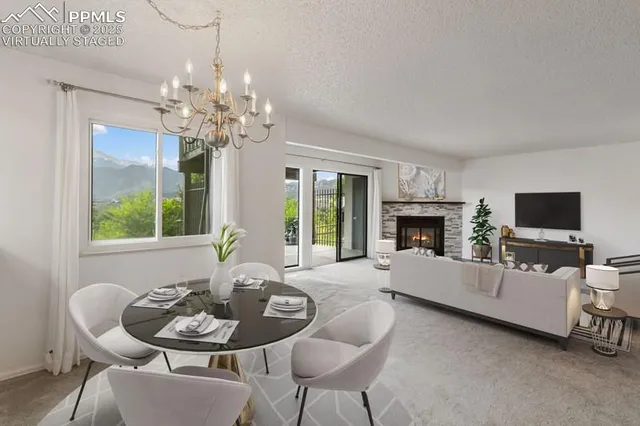 a living room with furniture a fireplace and a chandelier