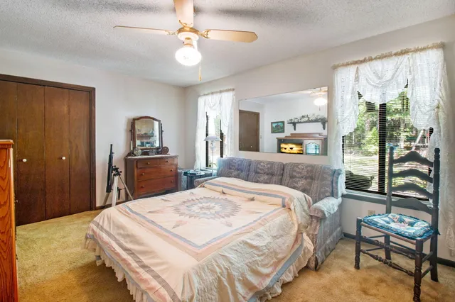 a bedroom with a bed a table and painting on the wall