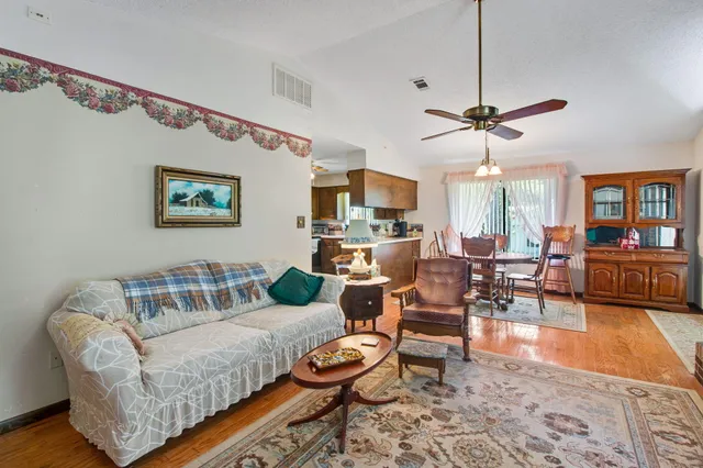 a living room with furniture a chandelier and a flat screen tv