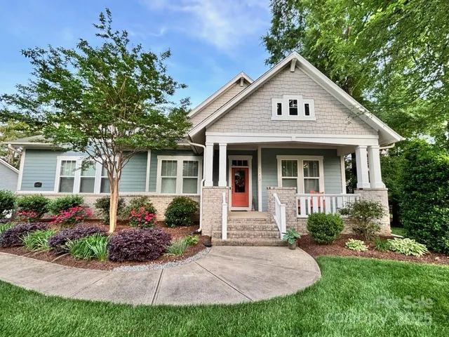 a front view of a house with a garden and plants