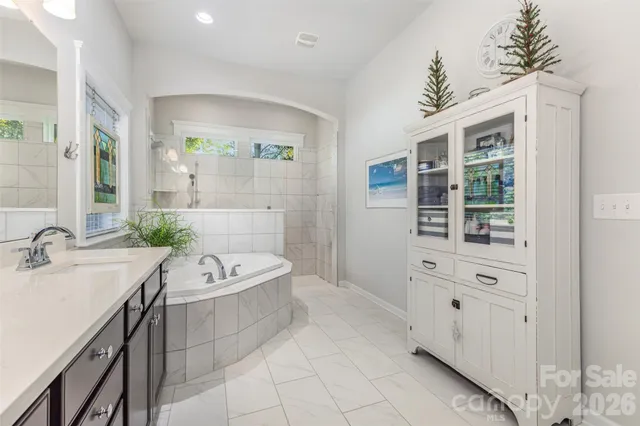 a bathroom with a tub sink and mirror
