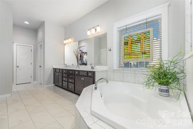 a bathroom with a tub sink and mirror
