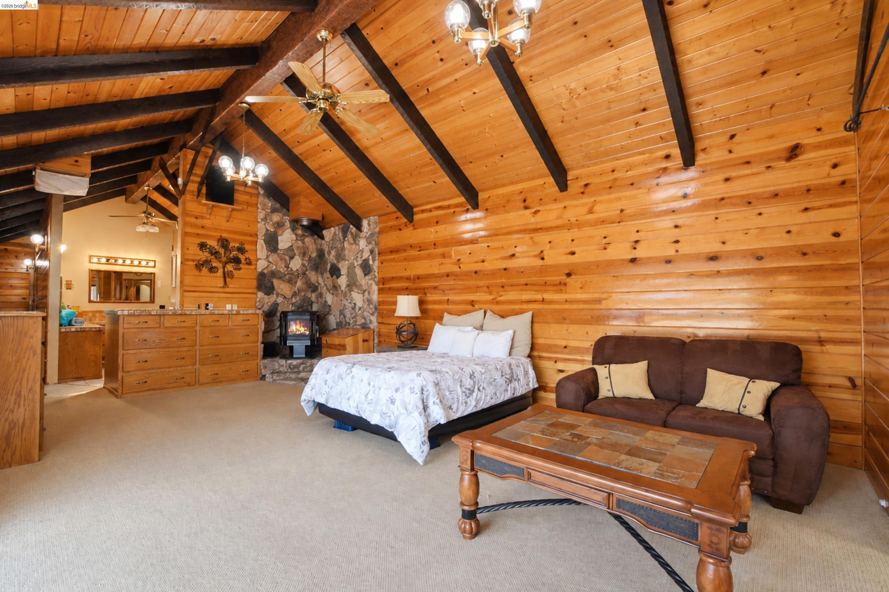 340 West Bolton Road Oakley, CA 94561 - Photo 45 of 87 Vaulted wood-paneled ceilings with exposed beams, stone fireplace with a wood-burning insert, wood-paneled walls, and a built-in wood vanity