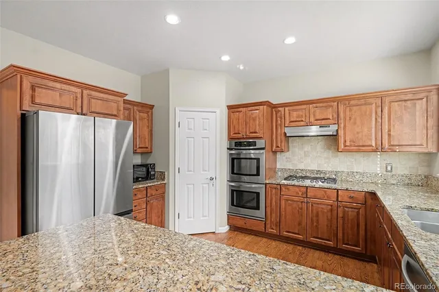 a kitchen with stainless steel appliances granite countertop a refrigerator and a sink