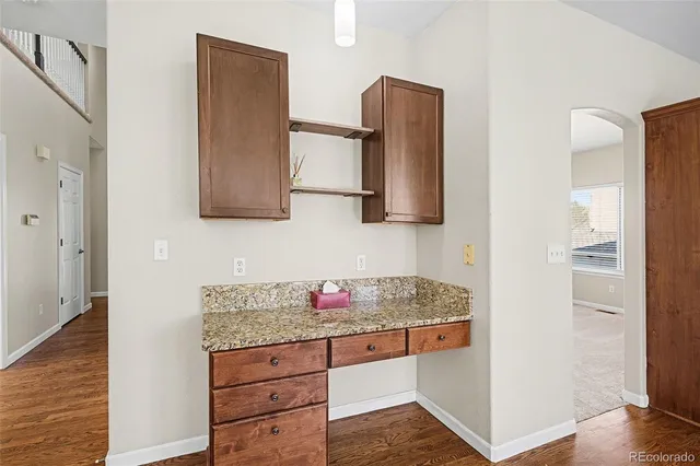 a hallway with granite countertop white cabinets and stainless steel appliances