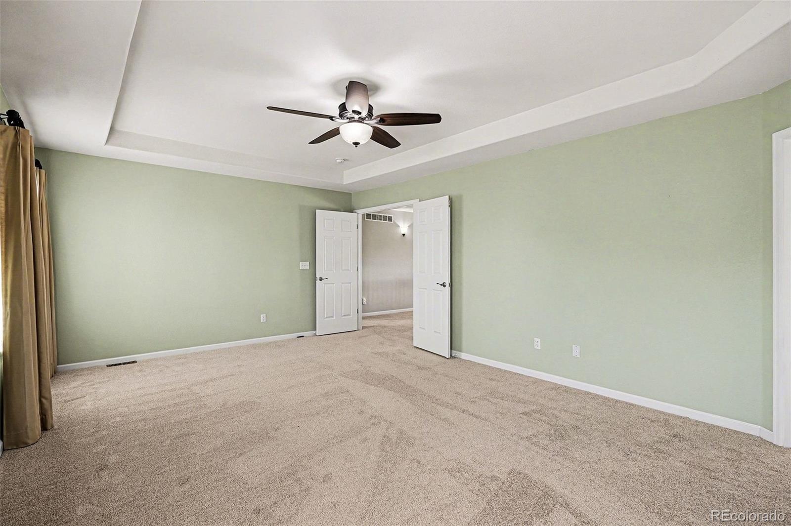 8046 Lodgepole Trail Lone Tree, CO 80124 - Photo 22 of 34 a view of an empty room with a ceiling fan