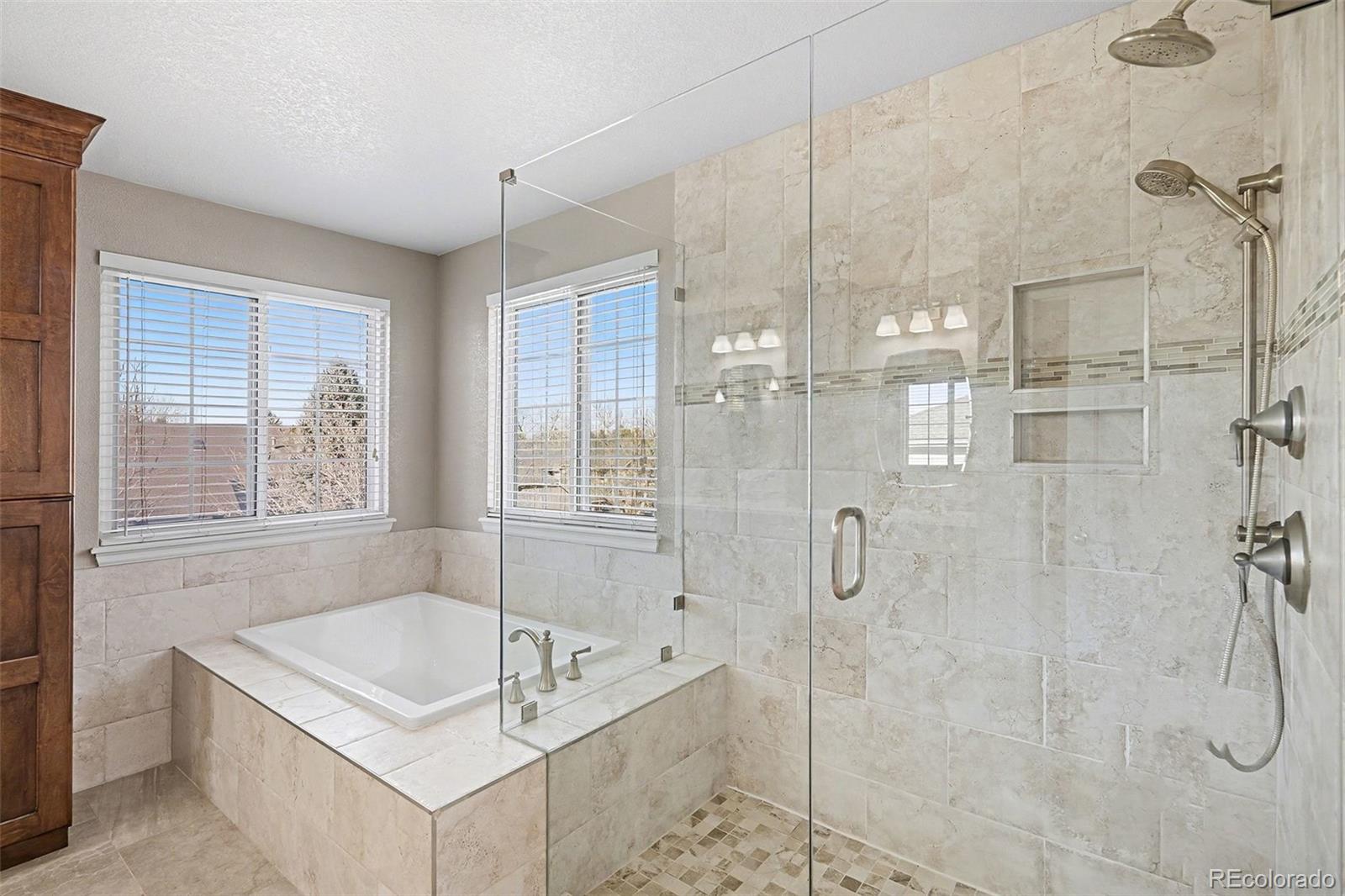 8046 Lodgepole Trail Lone Tree, CO 80124 - Photo 23 of 34 a bathroom with a tub a sink and shower