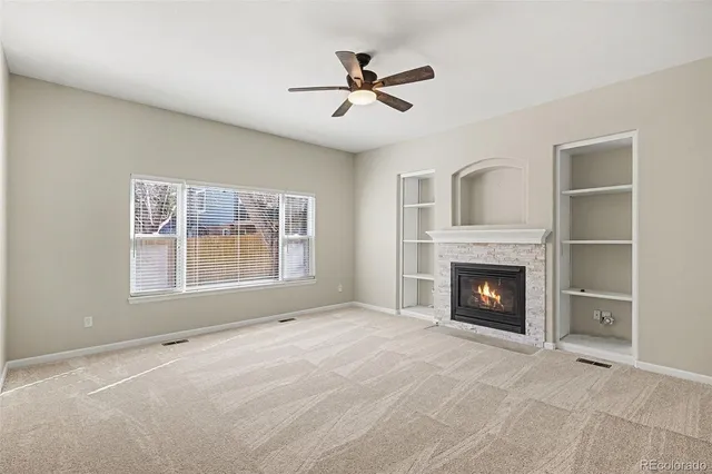 a view of an empty room with a fireplace and a window