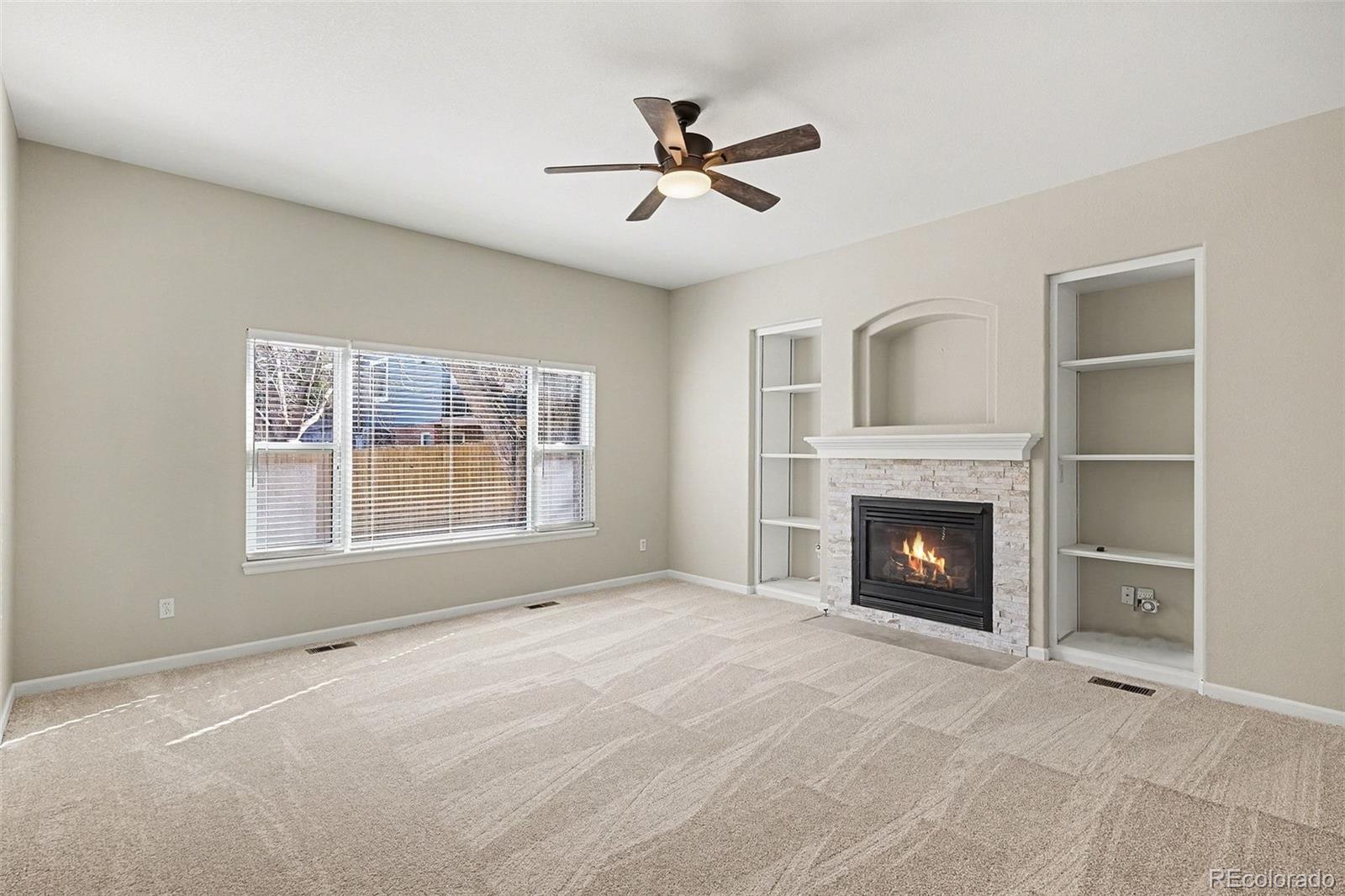 8046 Lodgepole Trail Lone Tree, CO 80124 - Photo 5 of 34 a view of an empty room with a fireplace and a window