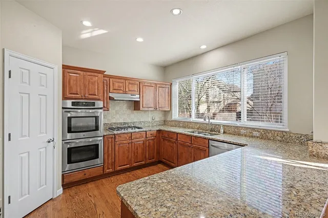 a kitchen with stainless steel appliances granite countertop a stove and a sink