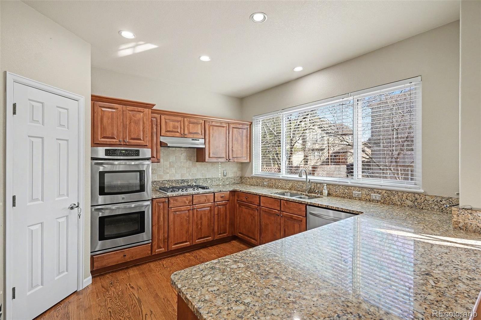 8046 Lodgepole Trail Lone Tree, CO 80124 - Photo 8 of 34 a kitchen with stainless steel appliances granite countertop a stove and a sink