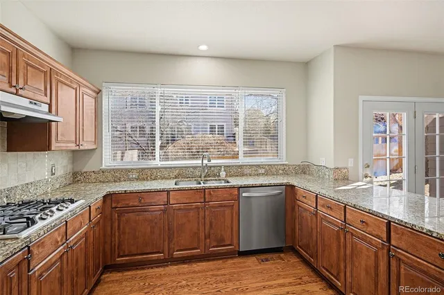 a kitchen with stainless steel appliances granite countertop a sink stove and cabinets