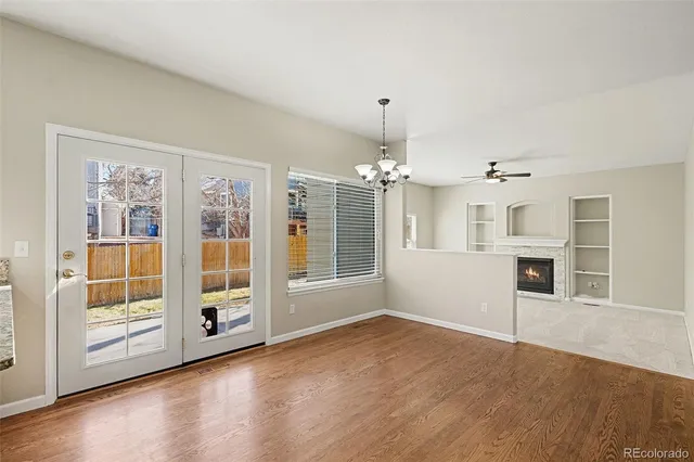 a view of a livingroom with wooden floor kitchen view and a window