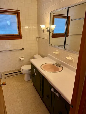a bathroom with a sink a toilet and mirror