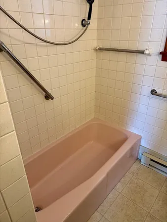 a bath tub sitting next to a white sink and a shower
