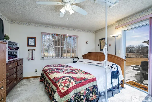 a bedroom with a bed and large windows