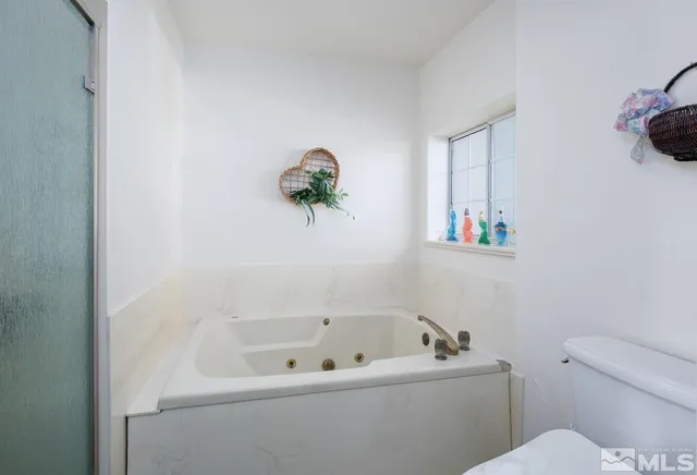 a bath tub sitting next to a white toilet and a sink
