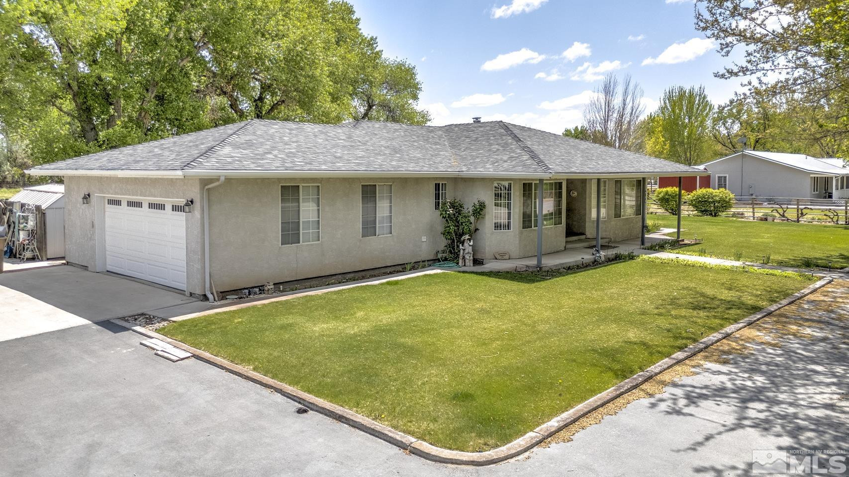 930 Edgewater Lane Fallon, NV 89406 - Photo 3 of 30 a view of a white house with a yard potted plants and a large tree