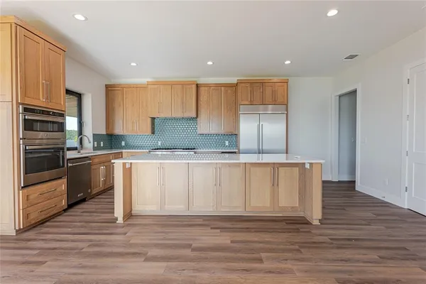 a kitchen with granite countertop white cabinets and stainless steel appliances