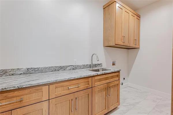 a bathroom with a granite countertop sink and cabinets