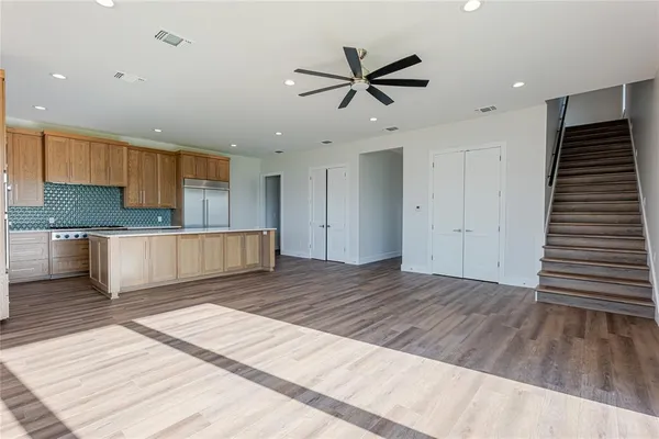 a view of a kitchen with wooden floor and a ceiling fan