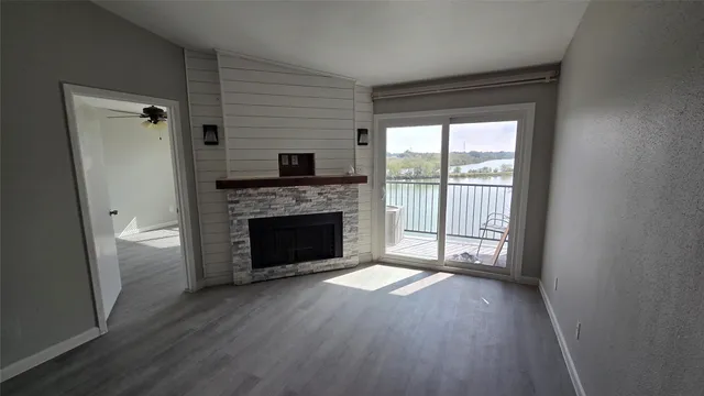 a view of a livingroom with a fireplace wooden floor and window