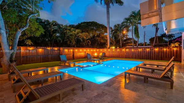 a view of a backyard with swimming pool and sitting area