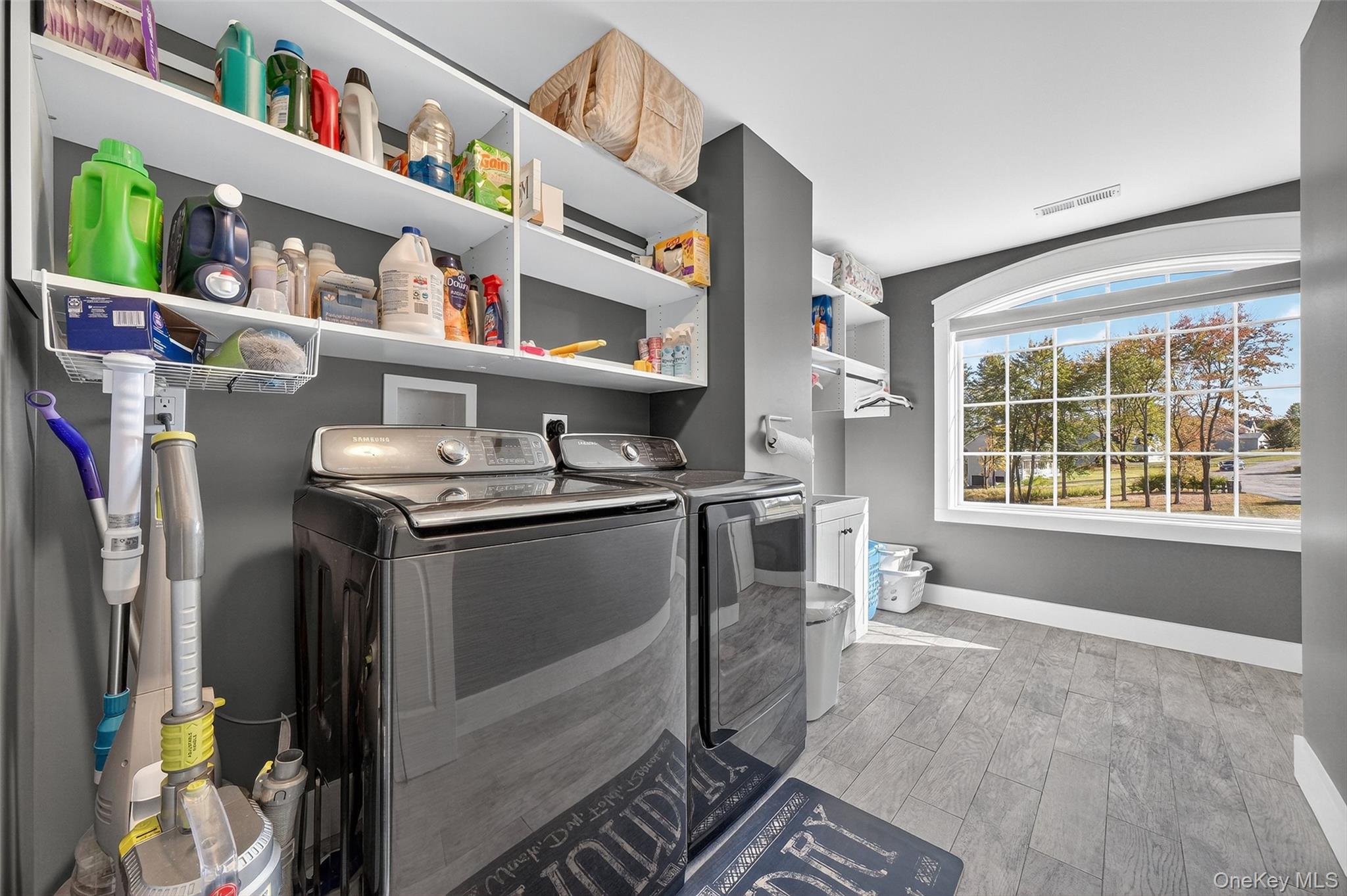 10 Domingues Road Newburgh, NY 12550 - Photo 6 of 30 Second Floor Laundry room featuring wood-finish flooring, built-in shelving, an arched window, and a gray wall color