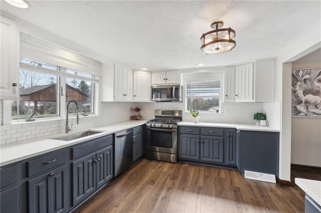 378 Mingo Church Road Finleyville, PA 15332 - Photo 18 of 48 a kitchen with wooden floors and white stainless steel appliances