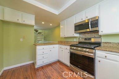 14 Featherwood Irvine, CA 92612 - Photo 17 of 32 a kitchen with stainless steel appliances white cabinets and a stove top oven